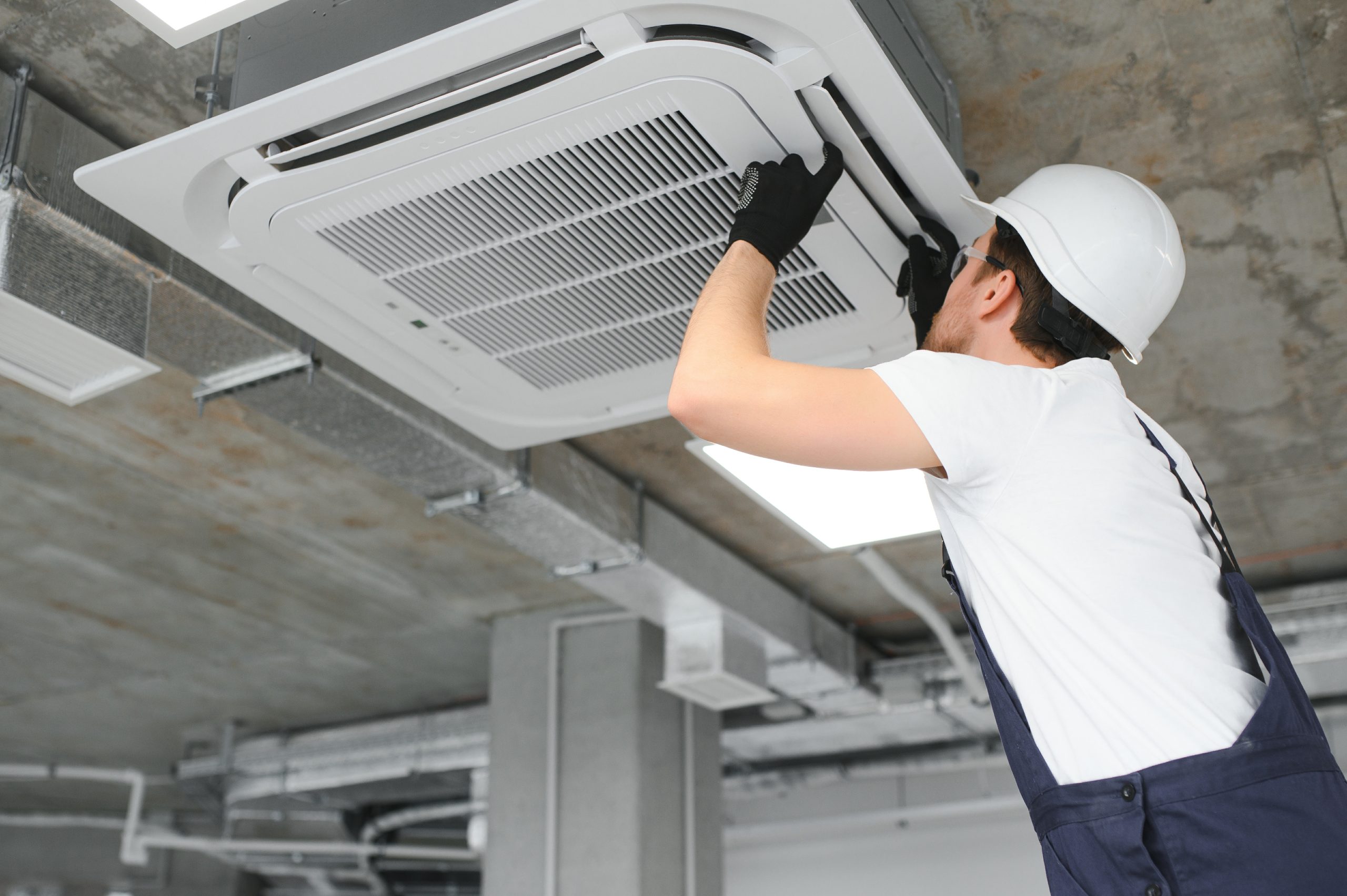 Happy Male Technician Repairing Air Conditioner.